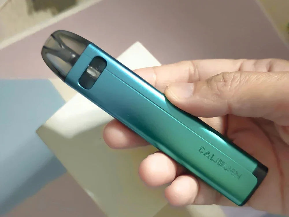 Hand holding Uwell Caliburn A2S Pod System - 520mAh, 2mL pod in teal, emphasizing its ergonomic grip and modern finish for easy vaping.