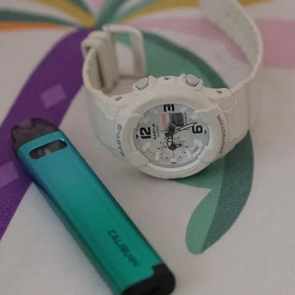 Uwell Caliburn A2S Pod System - 520mAh, 2mL pod next to a white G-Shock watch, highlighting its portable size and stylish appearance.